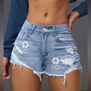 Ripped light blue denim shorts with flower designs